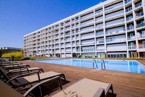 a large building with a swimming pool in front of a building at New loft with swimming pool at Parque das Nações! in Lisbon