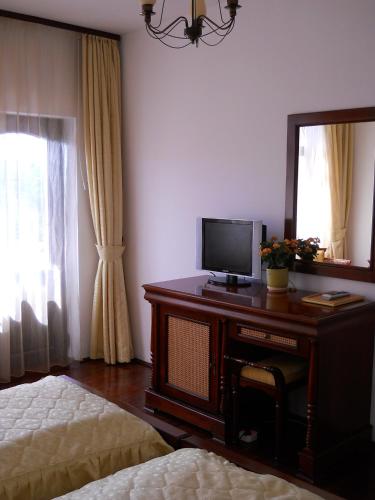 a bedroom with a desk with a television and a mirror at Casa Domneasca in Curtea de Argeş