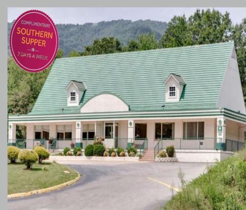 a house with a green roof on a road at Days Inn by Wyndham Asheville West in Candler