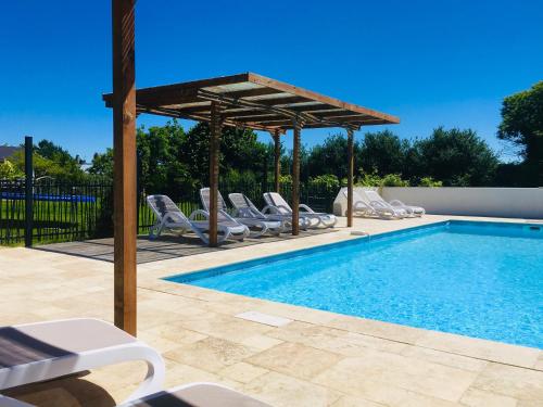- une piscine avec des chaises et un pavillon dans l'établissement Gîtes Les Neuf Cerisiers, à Mascaras