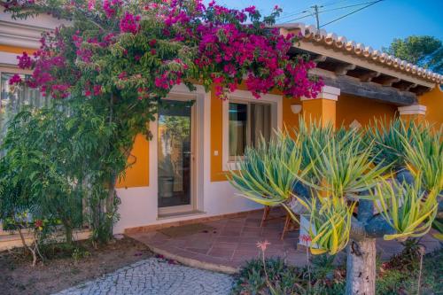 a house with pink flowers on the front of it at Moonshine Guest House with private studios and private cottage in Lagos