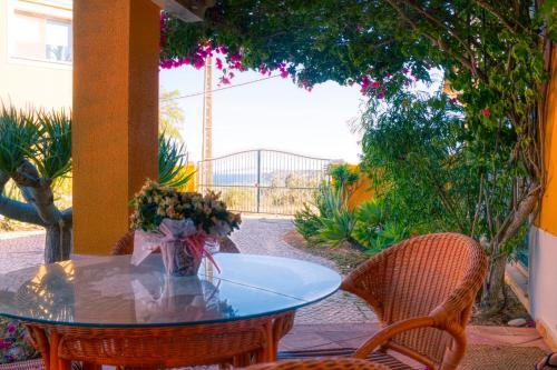 a table with a vase of flowers on a patio at Moonshine Guest House with private studios and private cottage in Lagos