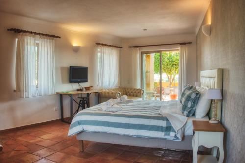 a bedroom with a bed and a desk and a television at Moonshine Guest House with private studios and private cottage in Lagos