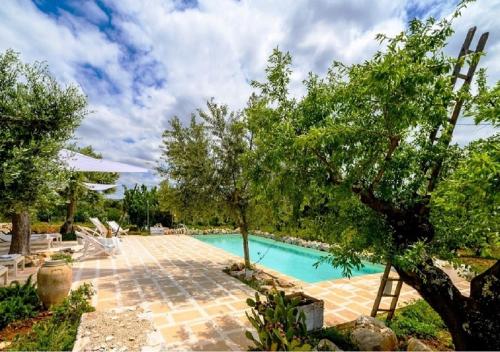 a swimming pool in a yard with trees at Masseria Montefieno in Castellana Grotte