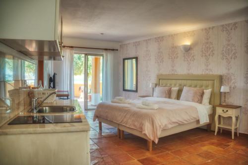 a bedroom with a bed and a kitchen with a sink at Moonshine Guest House with private studios and private cottage in Lagos