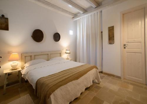 ein Schlafzimmer mit einem großen Bett und einer Tür in der Unterkunft Masseria Montefieno in Castellana Grotte