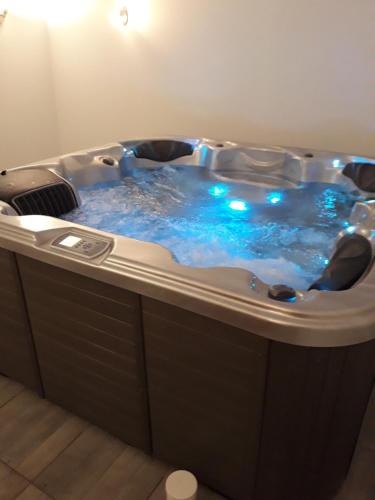 a jacuzzi tub with blue water in a room at Hôtes de l'Isle in Saint-Médard-de-Mussidan