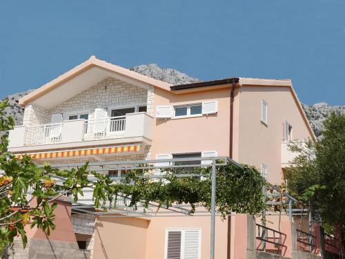 een roze appartementencomplex met een balkon bij Apartments Villa Michele in Orebić