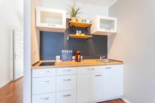 a kitchen with white cabinets and a sink at Amazing View in Drasnice