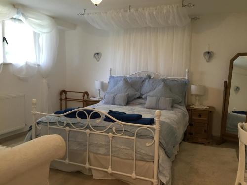 une chambre avec un lit blanc avec des oreillers bleus dans l'établissement Le Petit Pont, à Magnac-Laval