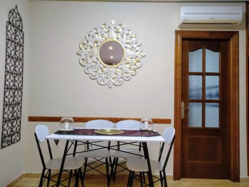 a dining room with a table and chairs and a mirror at HOME STAR VI con vistas in Vera