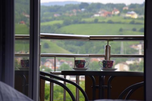 two coffee cups sitting on a table in front of a window at Apartmani Marić in Novi Pazar