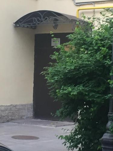 una puerta de garaje negra con un árbol delante en Guest House "Nevsky 6", en San Petersburgo