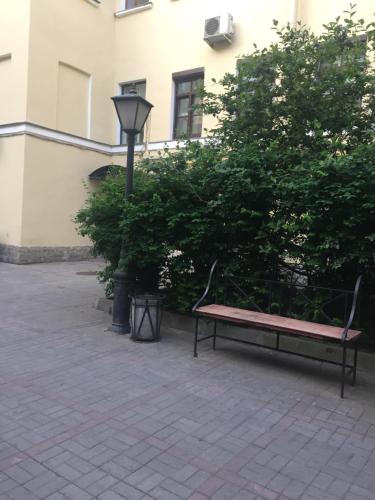 un banco de parque junto a un árbol y un semáforo en Guest House "Nevsky 6", en San Petersburgo