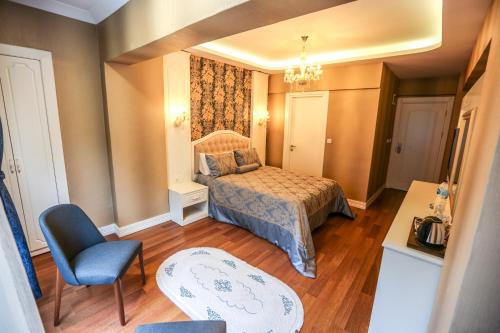 a small bedroom with a bed and a chair at Thermal Saray Hotel & Yalova in Gokcedere
