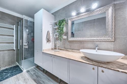 a bathroom with a sink and a shower and a mirror at Apartment Villa Hacijenda with private pool and jacuzzi in Kaštela