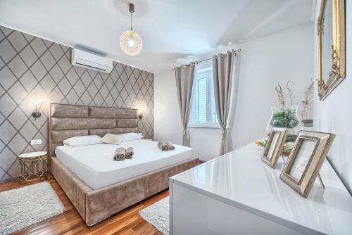 a bedroom with a large white bed and a window at Apartment Villa Hacijenda with private pool and jacuzzi in Kaštela