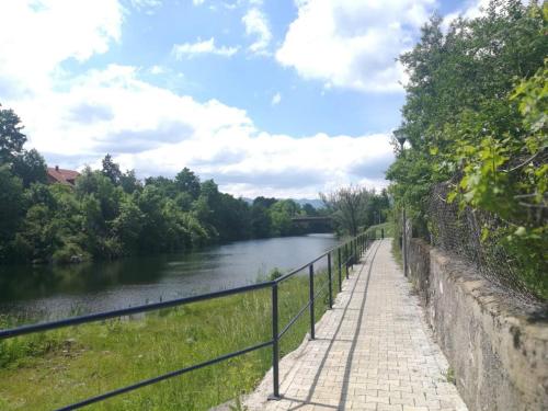 a walkway next to a river next to a fence at River View Apartment Gospic in Gospić