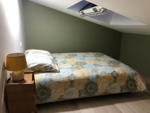 - une chambre avec un lit et une lampe sur une table de chevet dans l'établissement Duplex avec piscine, à Villenave-dʼOrnon