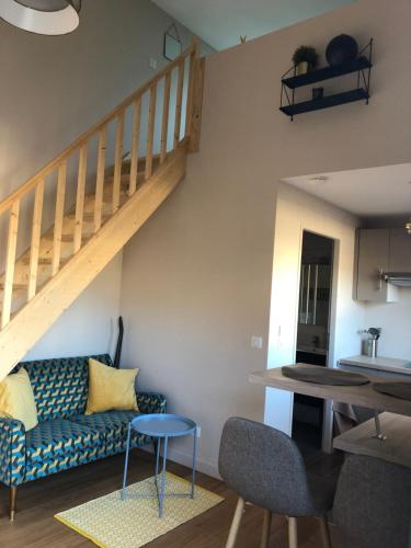 un salon avec un canapé et un escalier dans l'établissement Duplex avec piscine, à Villenave-dʼOrnon