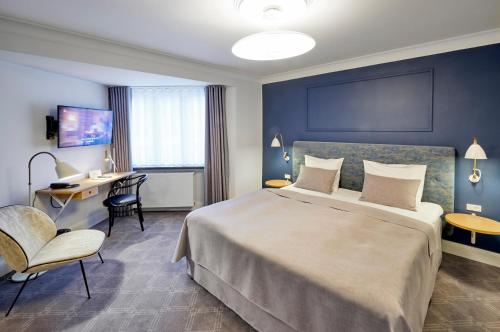 a hotel room with a large bed and a chair at Hotel Randers in Randers