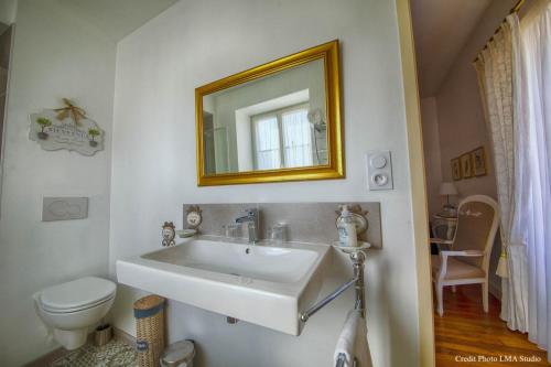 a bathroom with a sink and a toilet and a mirror at Maison d'hôtes de charme La Rose de Ducey près du Mont Saint Michel in Ducey