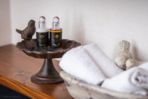 a table with a basket of towels and two bottles at Maison d'hôtes de charme La Rose de Ducey près du Mont Saint Michel in Ducey