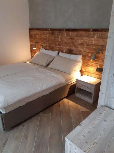 a bedroom with a large bed with a wooden headboard at Ledro Nest in Ledro