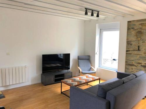 a living room with a couch and a tv at Le Duplex in Cherbourg en Cotentin