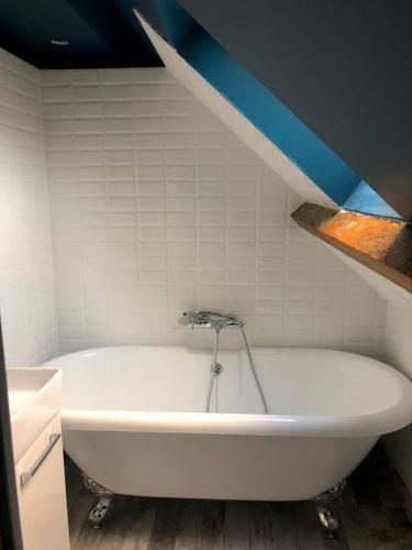 a white bath tub in a bathroom with a blue ceiling at Le Duplex in Cherbourg en Cotentin