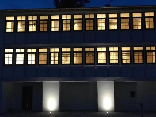 an office building with illuminated windows at night at A Casa da Botica in Samos