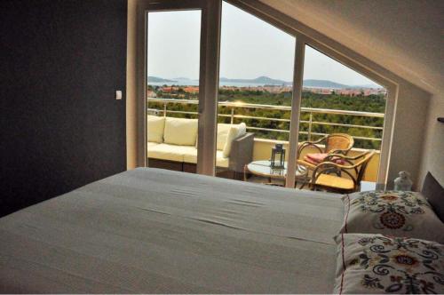 Un dormitorio con una cama y una ventana grande. en Sun&Sea Apartment, en Vodice