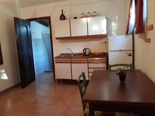 a kitchen with a table and a refrigerator at S'Imbragu Farm B&B in Tortolì