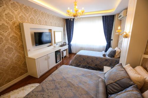 a living room with two beds and a tv at Thermal Saray Hotel & Yalova in Gokcedere