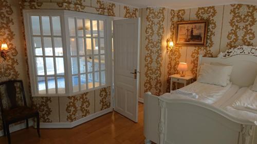 a bedroom with a white bed and a window at Garvaregården Hotel , B&B och Café in Askersund