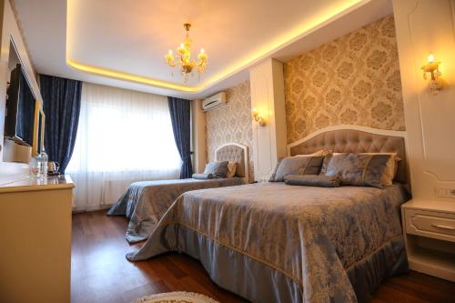 a bedroom with two beds and a chandelier at Thermal Saray Hotel & Yalova in Gokcedere