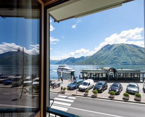 a view from a window of a parking lot with a boat at Hotel Argegno in Argegno