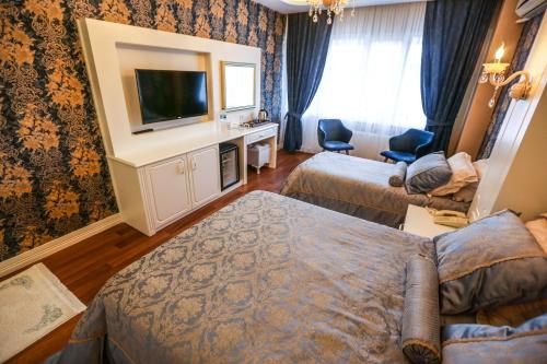 a hotel room with two beds and a flat screen tv at Thermal Saray Hotel & Yalova in Gokcedere