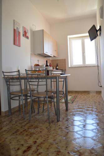 a kitchen with a table and chairs in a room at 21mq Home Petrolla in Villanova di Ostuni