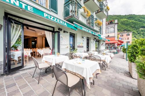 a restaurant with tables and chairs in front of a building at Hotel Argegno in Argegno