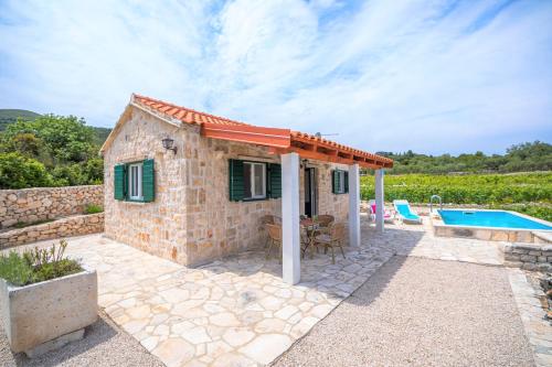 a small stone house with a swimming pool at Vineyard House & Olive Grove House in Račišće