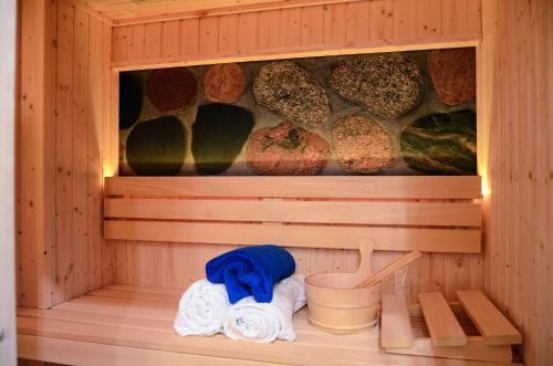 a wooden sauna with towels and a bucket in it at Uroczysko Lubiaszów in Nowy Lubiaszów