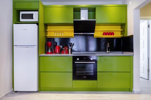 a kitchen with green cabinets and a white refrigerator at Twin Apart Hotel in Alanya