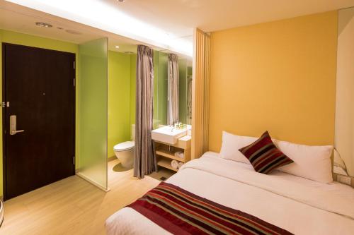 a bedroom with a bed and a bathroom with a sink at Crystal Inn Sun Moon Lake in Yuchi