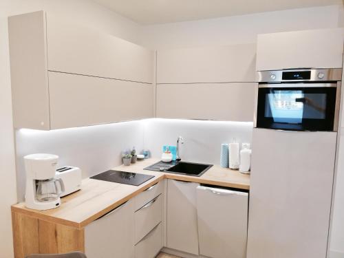 a kitchen with white cabinets and a counter top at De Luxe Blue Mare in Łukęcin