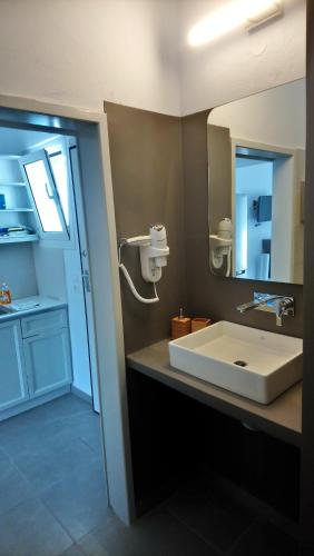 a bathroom with a white sink and a mirror at Niso in Livadion
