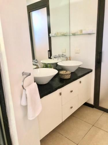 a bathroom with two sinks and a mirror at Beach Apartment - Trou aux Biches - Ground Floor in Mont Choisy