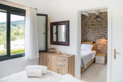 a bedroom with a bed and a mirror at Villa Venetia Corfu in Agnítsini