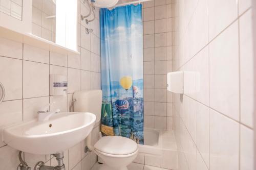 Baño blanco con lavabo y aseo en Apartments Amalia, en Podgora