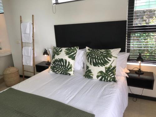 a bedroom with a white bed with two pillows at Beach Apartment - Trou aux Biches - Ground Floor in Mont Choisy